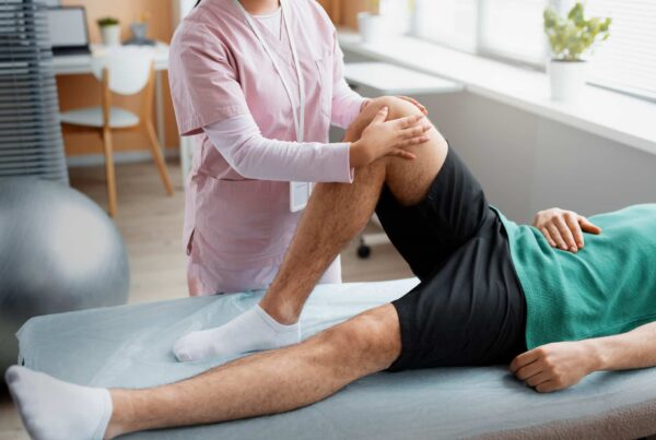 Doctor assisting patient through physical rehabilitation for injury recovery and mobility
