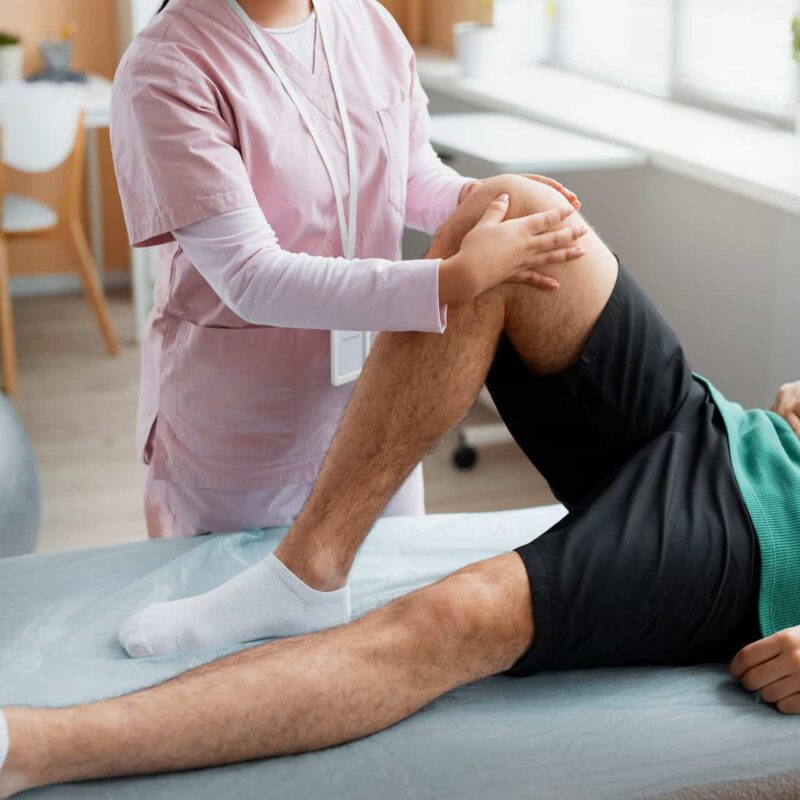 Doctor assisting patient through physical rehabilitation for injury recovery and mobility