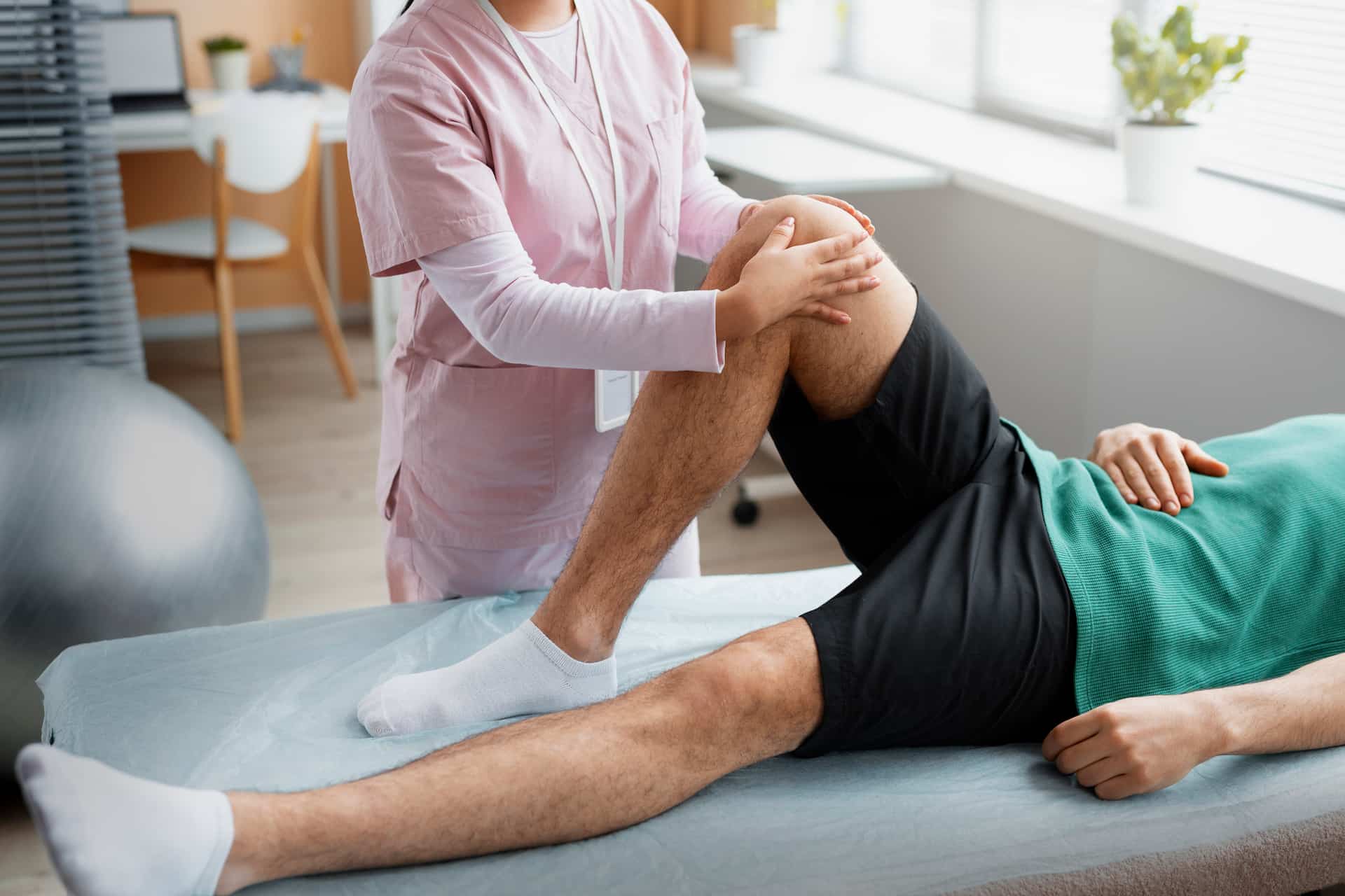 Doctor assisting patient through physical rehabilitation for injury recovery and mobility
