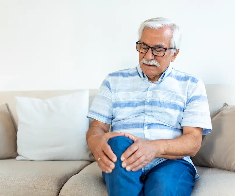 Older adult experiencing knee pain due to age-related joint wear and stiffness