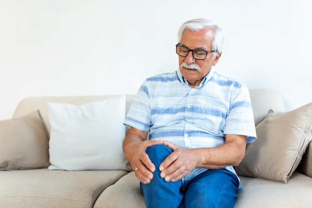 Older adult experiencing knee pain due to age-related joint wear and stiffness