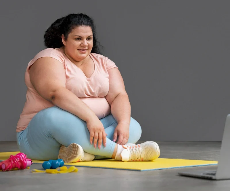 Person holding knee due to joint pain related to excess weight