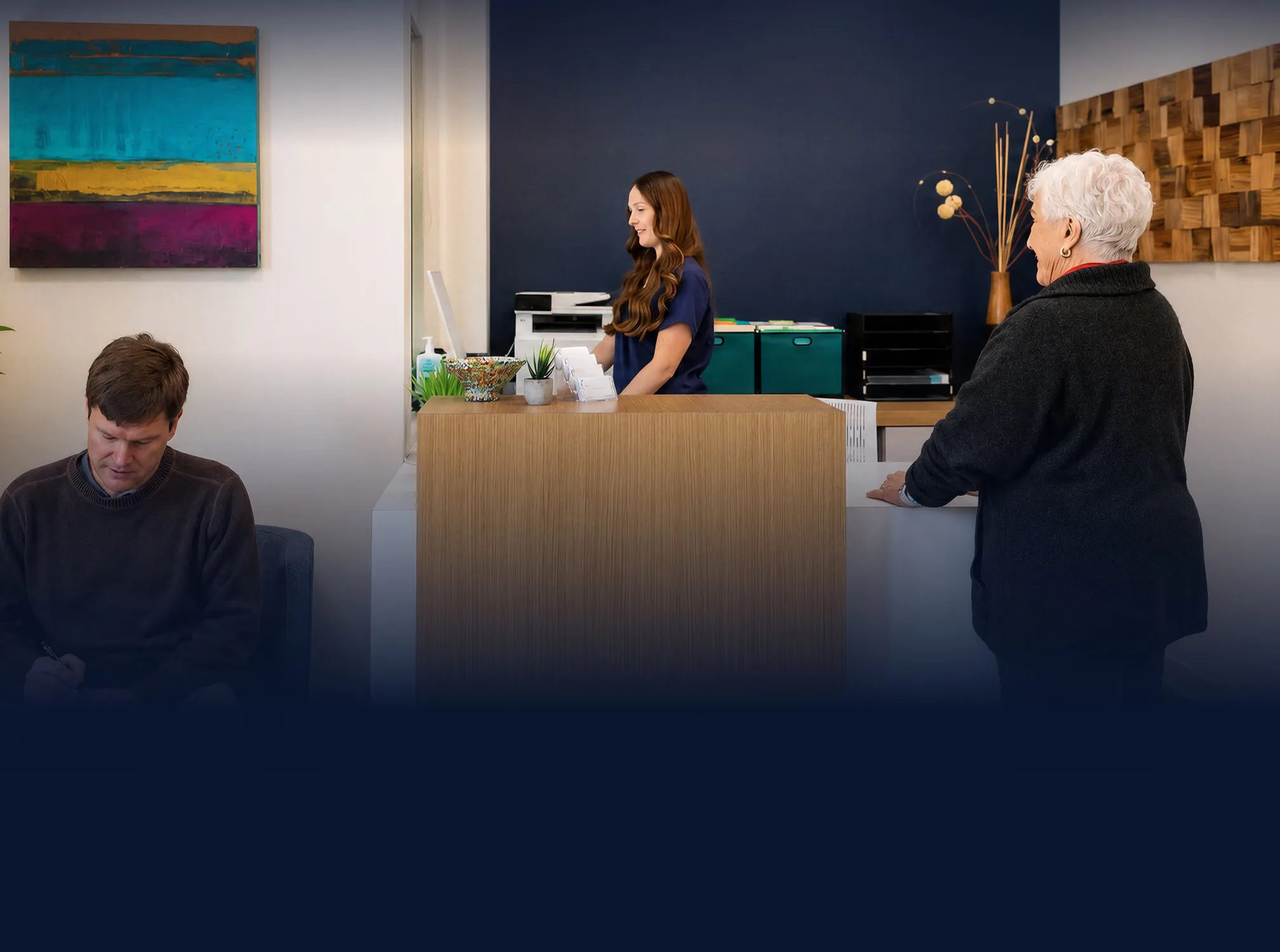 Patient checking in at the Marin Joint Health front desk while another patient waits