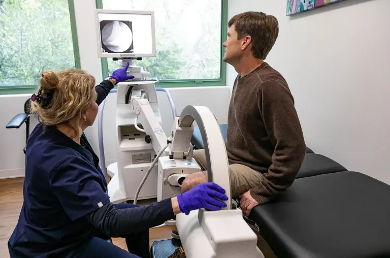 Clinician treating a patient knee with a therapy device at Marin Joint Health